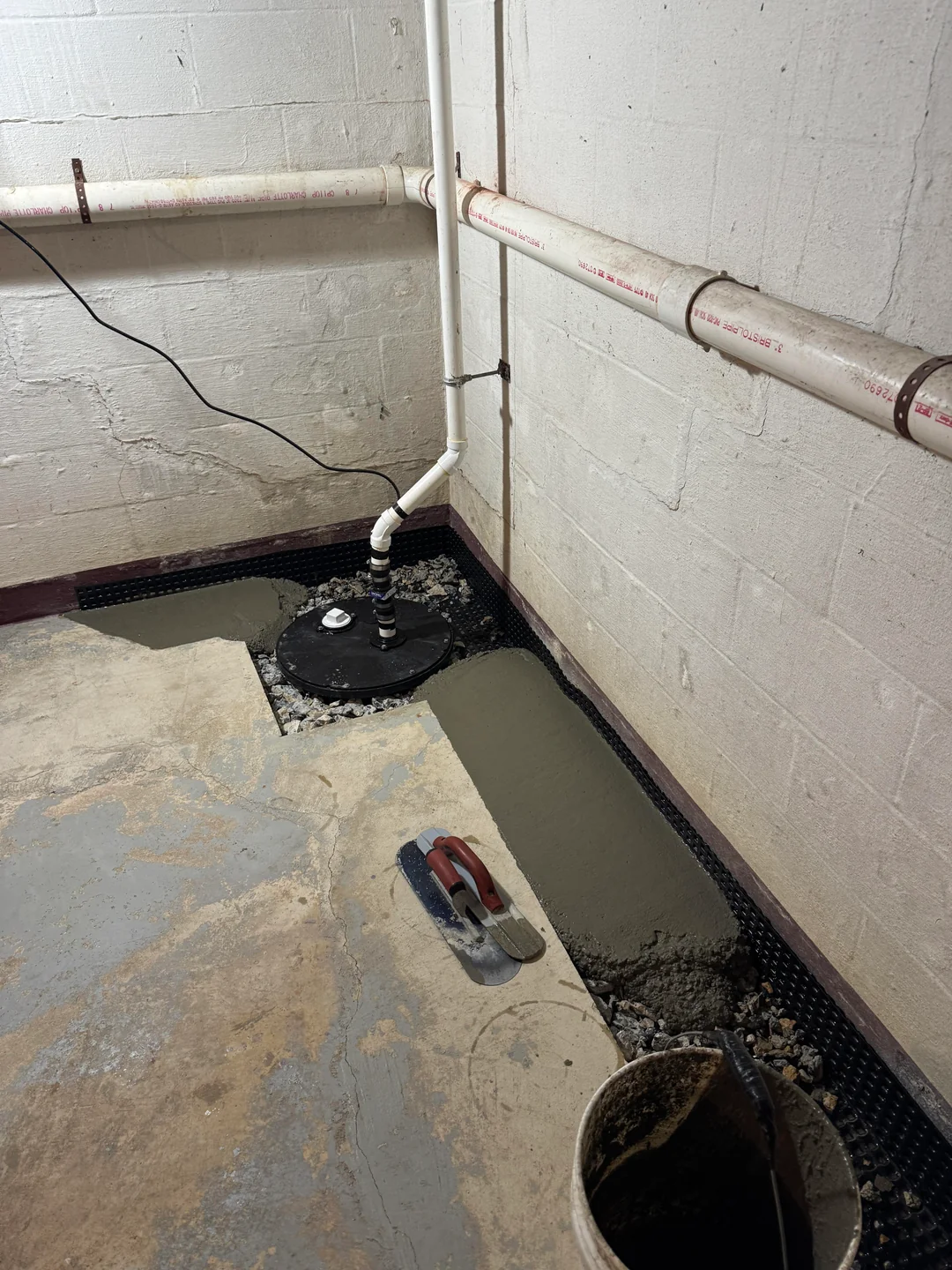 Below-slab basement waterproofing installed in a Northside home in Syracuse, NY