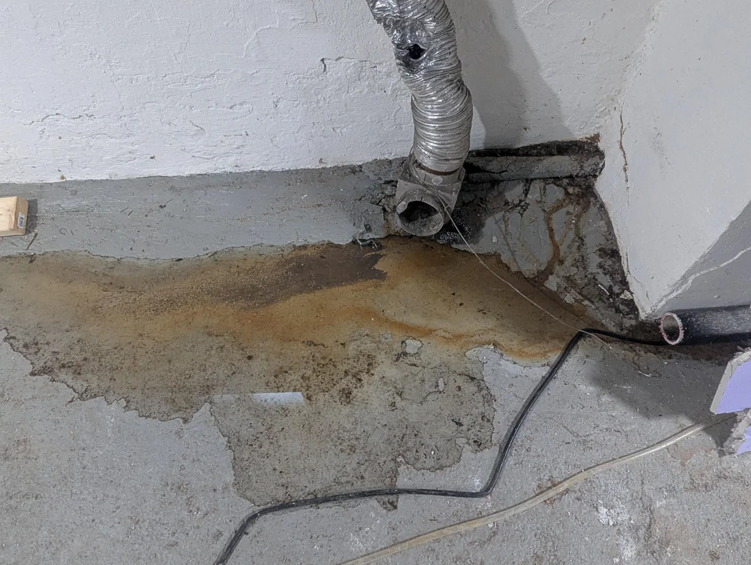 Water pooling on a Syracuse basement floor before basement waterproofing was installed